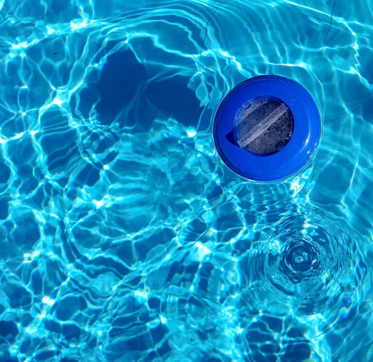 Plastic chlorine dispenser and blue water seen from above